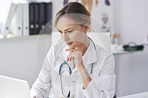 Female doctor working with laptop in her doctorÃ¢â¬â¢s office photo